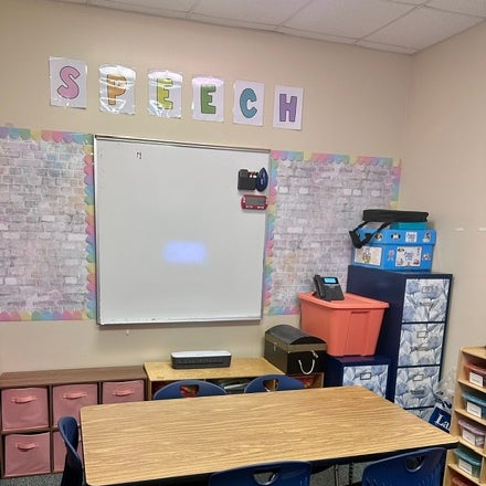 Speech therapy room with a whiteboard and student tables Speech therapy room with a whiteboard and student tables